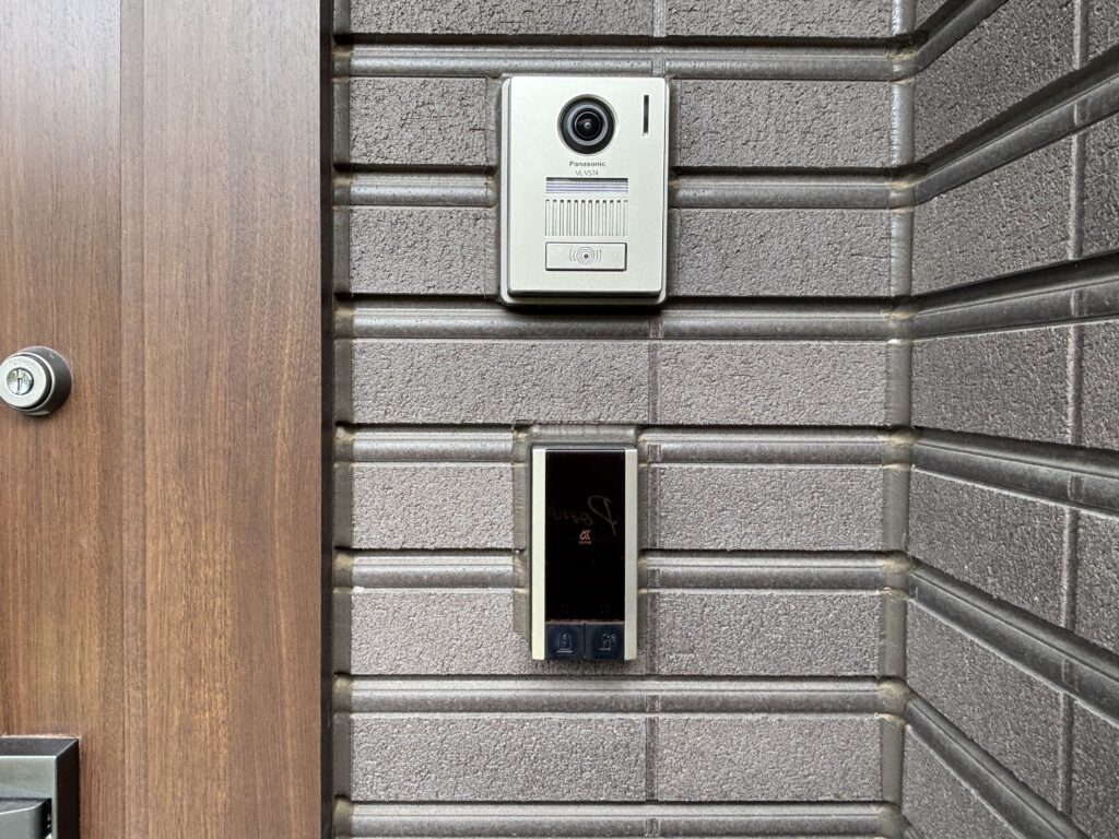 陶板外壁に取り付けられたインターホンと玄関ドア